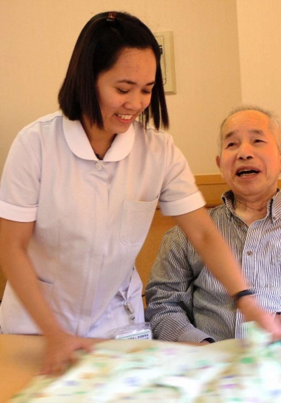 介護施設でお年寄りに接するフィリピン人の女性